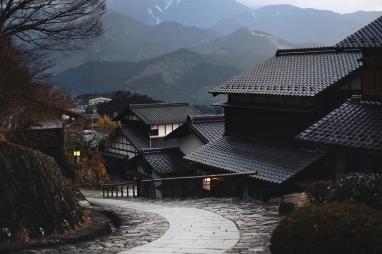 Scenic view of a traditional Japanese village nestled in the mountains during twilight.